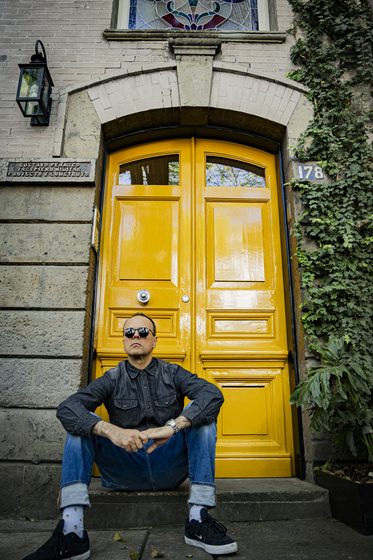 Sentado frente a una puerta amarilla, Ciudad de México, 2024